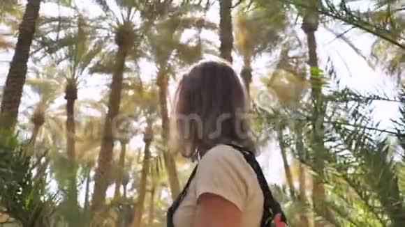 一个女孩穿过棕榈丛林视频的预览图