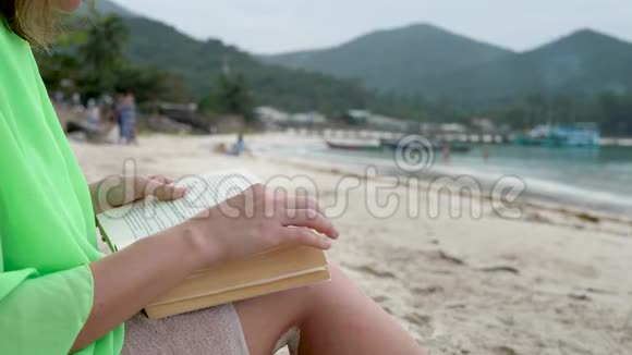 女性阅读海滩书籍视频的预览图