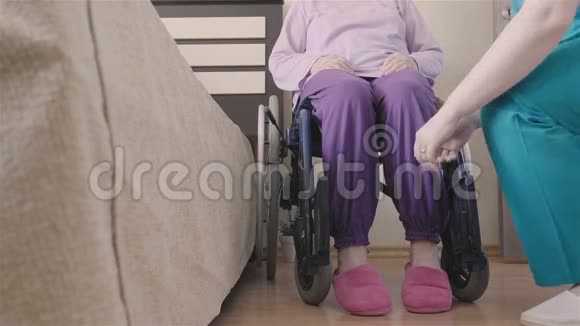 照顾轮椅残疾长者的年轻护士视频的预览图