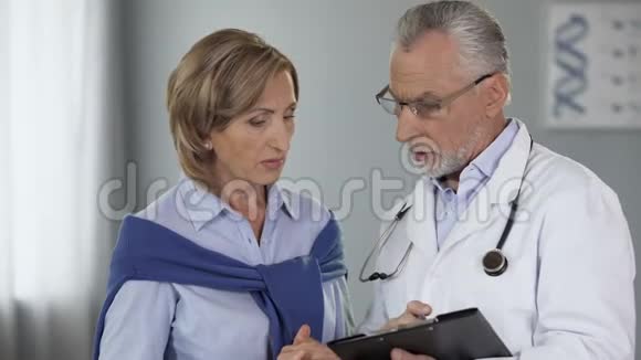 老年医生与女性患者交谈显示结果疾病和治疗方法视频的预览图