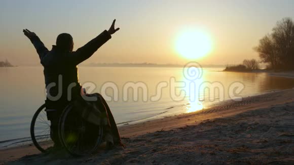 日落双手放在轮椅上孤独残疾人坐在轮椅上男性视频的预览图