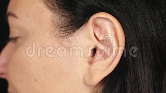 女性左耳靠近成年黑发女人的耳朵脸部和身体部位视频的预览图