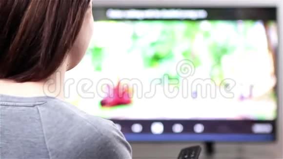 遥控看智能电视的年轻女子视频的预览图