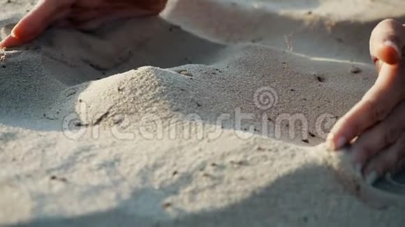 下面的动作结束沙子穿过一个年轻女人的手指沙子穿过了一个视频的预览图