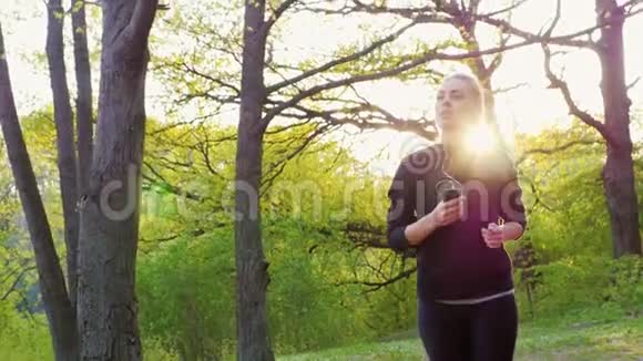 慢镜头在森林里奔跑的年轻女子健康生活和运动视频的预览图
