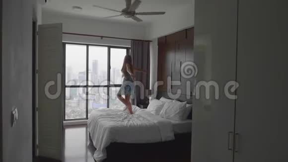 快乐的女人在床上跳视频的预览图
