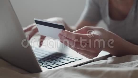 在床上用信用卡网上购物的女孩视频的预览图