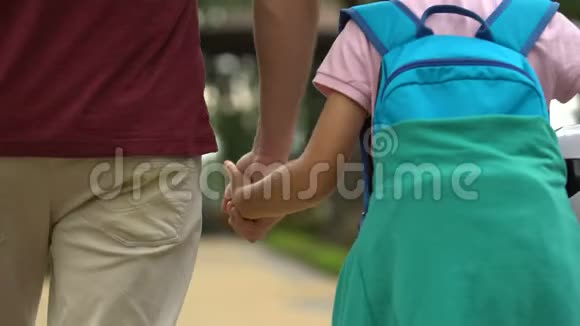 父亲放学后和儿子步行回家讨论体育课足球视频的预览图