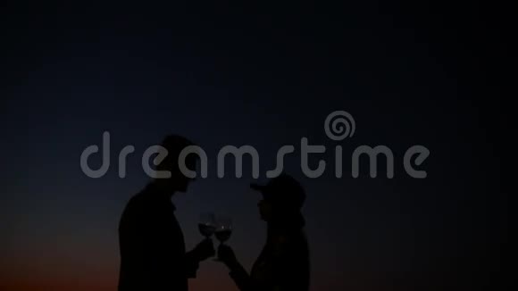 日落时分在海边喝酒的夫妇视频的预览图