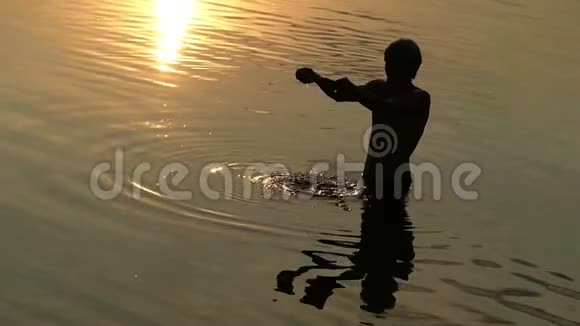 精神人在斯隆莫的夕阳下手握河水视频的预览图
