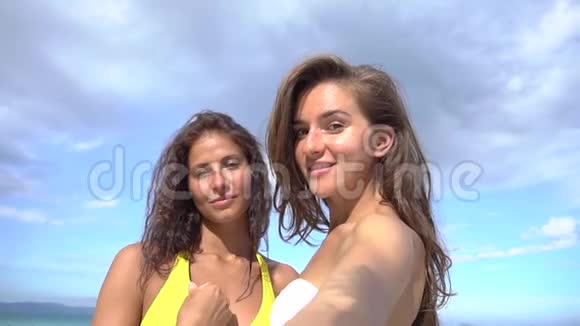 美丽的女孩在海滩上用手机自拍微笑着旋转着享受大自然的假期视频的预览图