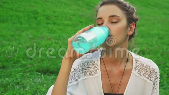 年轻女孩在做瑜伽时喝水视频的预览图