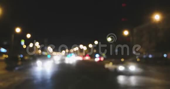 夜间交通灯散焦蓝色的汽车灯光分成两股流镜头向左平移视频的预览图