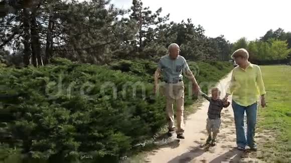 小男孩和爷爷奶奶在公园散步视频的预览图