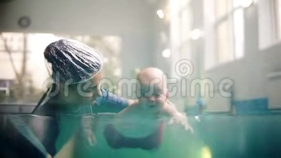 可爱的男孩在游泳池里学习水下游泳婴儿用张开的眼睛在水下游泳健康的家庭生活方式视频的预览图