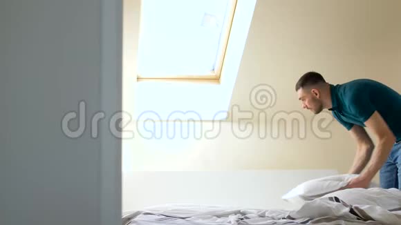 快乐的男人在家整理床铺视频的预览图