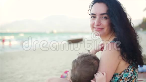 一位怀抱婴儿的迷人母亲的肖像妈妈带着宝宝在享受新鲜空气妈妈在哺乳视频的预览图