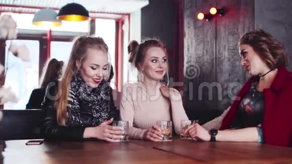 三个时髦的家庭主妇在酒吧休息喝鸡尾酒互相交谈开玩笑快乐时光视频的预览图