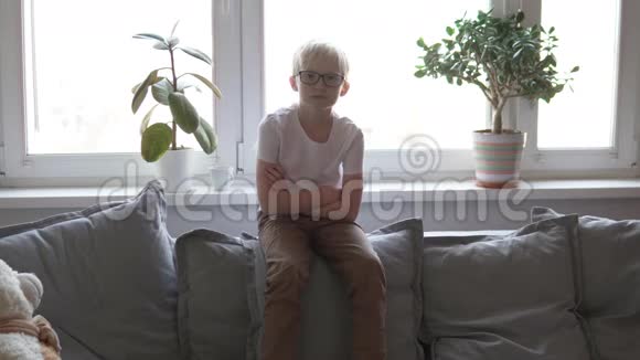 男孩坐在家里的沙发上视频的预览图