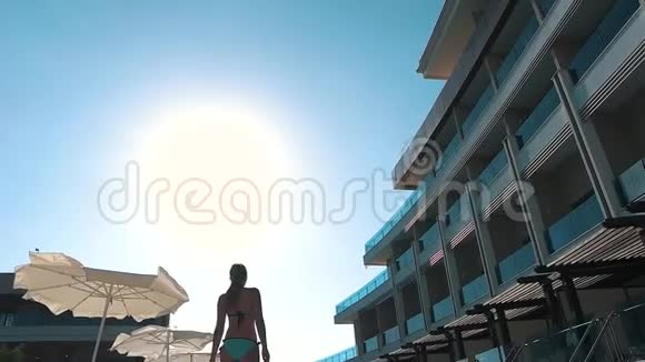 女孩正走在海滩酒店游泳池附近视频的预览图