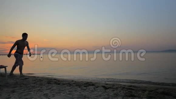 日落时在海边表演杂技的男人视频的预览图