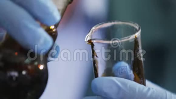 助理将生油从灯泡倒入实验室玻璃视频的预览图