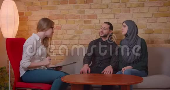 一对年轻快乐的穆斯林夫妇与一个新的公寓讨论并签署了协议视频的预览图