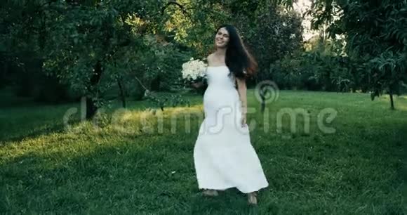 年轻漂亮的孕妇棕色长发穿着白色连衣裙4k幸福的女人转过身来视频的预览图