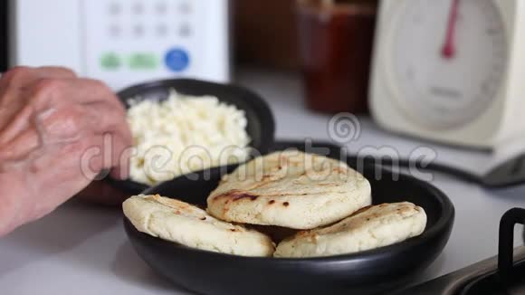 女人把奶酪丝加到烤饼里视频的预览图