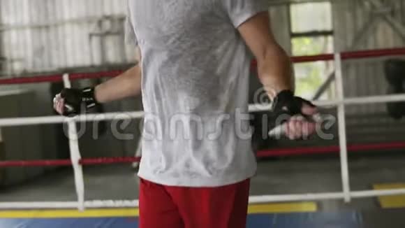 年轻的男拳击手用绷带包裹在拳击馆里跳绳慢动作拳击视频的预览图