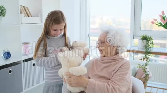 年老的女人和女孩玩视频的预览图