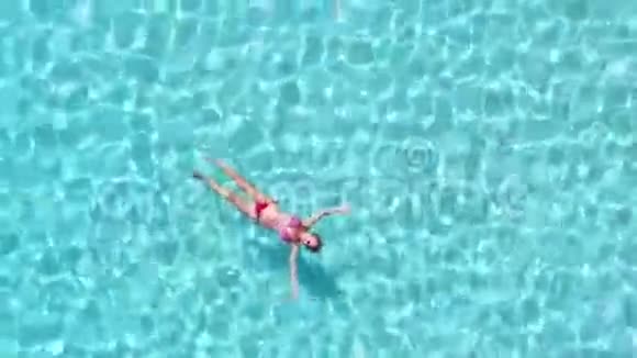 空中旋转的景色一个迷人的女人漂浮在晶莹剔透的海面上视频的预览图