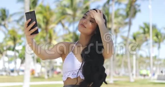 时髦的黑发女人在阳光下自拍视频的预览图