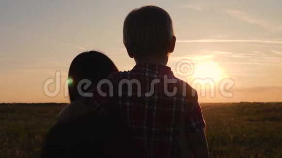 一个幸福的家庭妈妈和儿子看日落在户外旅行和散步幸福健康的理念视频的预览图