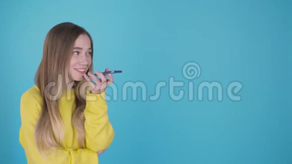 室内肖像迷人的年轻欧洲妇女隔离在彩色背景持有空白智能手机使用声音视频的预览图