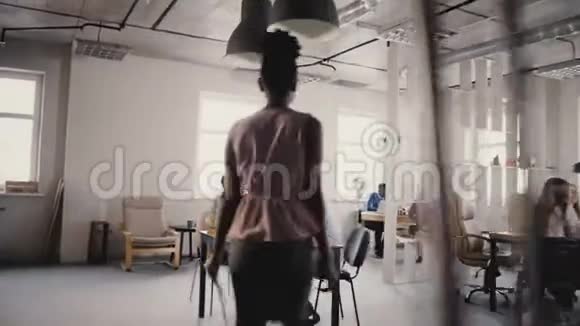 镜头跟随非裔美国女老板进入办公室给工人指路小组团队合作4K视频的预览图