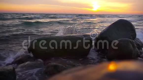 海水和石头附近的日落缓慢运动的海浪视频的预览图