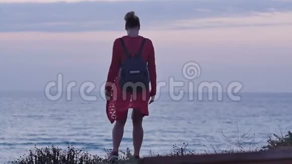 黄昏走在海边的年轻女子视频的预览图