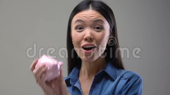 微笑的亚洲女士摇动储蓄罐省钱技巧财政和预算视频的预览图