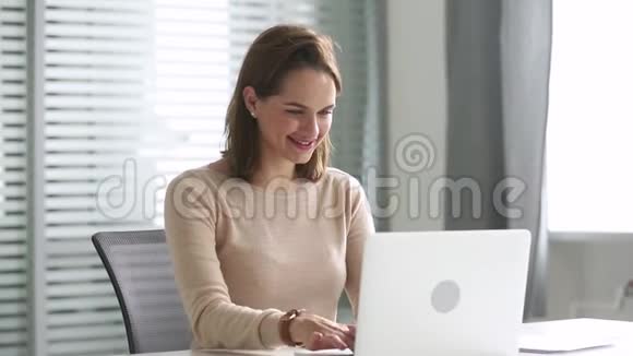 快乐的商务女性坐在办公桌前用电脑在线交流视频的预览图