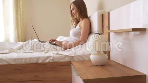 女人在床上用笔记本电脑打字视频的预览图