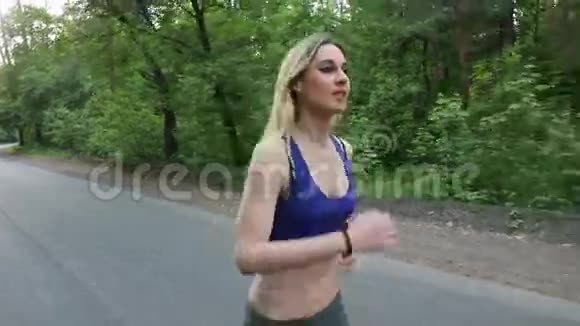 在森林里的路上跑的女孩户外健身特写镜头用安定剂射击视频的预览图