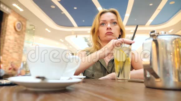 悲伤的女人在咖啡馆等人喝茶4k慢镜头特写复印空间视频的预览图