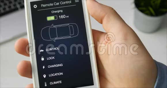 人检查他的车的收费水平正在充电汽车遥控使用智能手机应用程序虚构视频的预览图