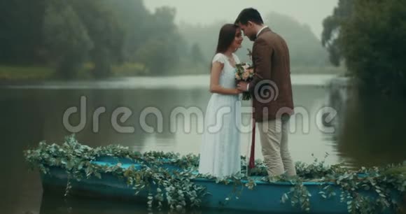 一对穿着复古布的美丽情侣正捧着这束美丽的花站在一起视频的预览图