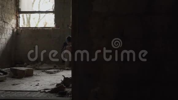 饥寒交迫的无家可归者在被遗弃的建筑物里坐着视频的预览图
