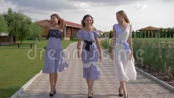 穿着裙子和高跟鞋走在公园人行道上的时髦漂亮女孩视频的预览图