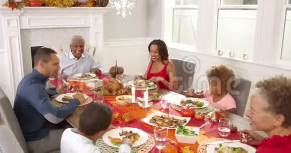 镜头跟踪显示大家庭围坐在餐桌旁吃感恩节大餐视频的预览图