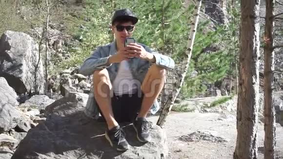 他坐在岩石上视频的预览图