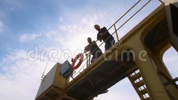 两个码头工人同事和同事看着摄像机手在一个工业视频的预览图